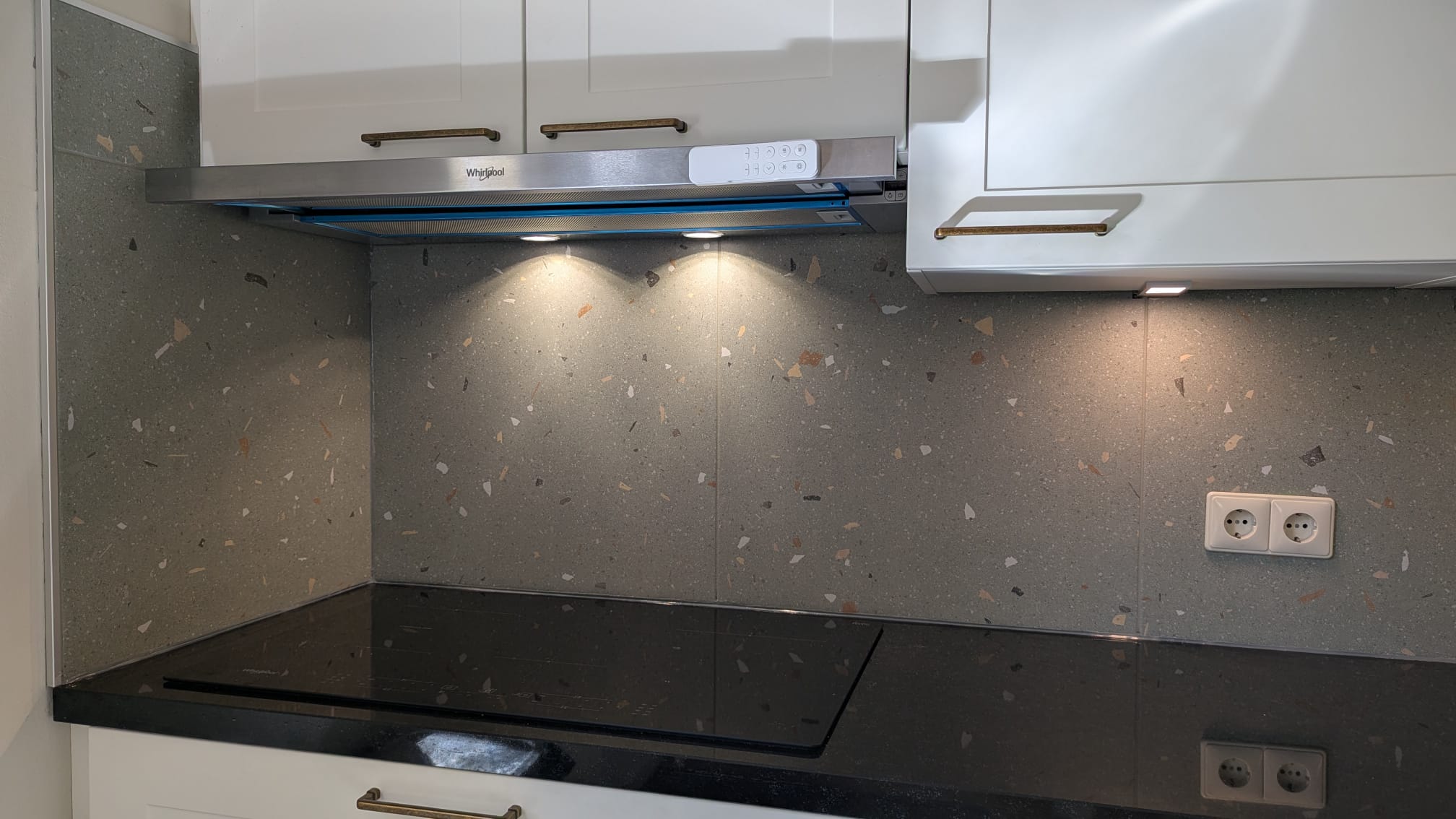 Terrazzo-look tegelwand achter een keukenkookplaat
